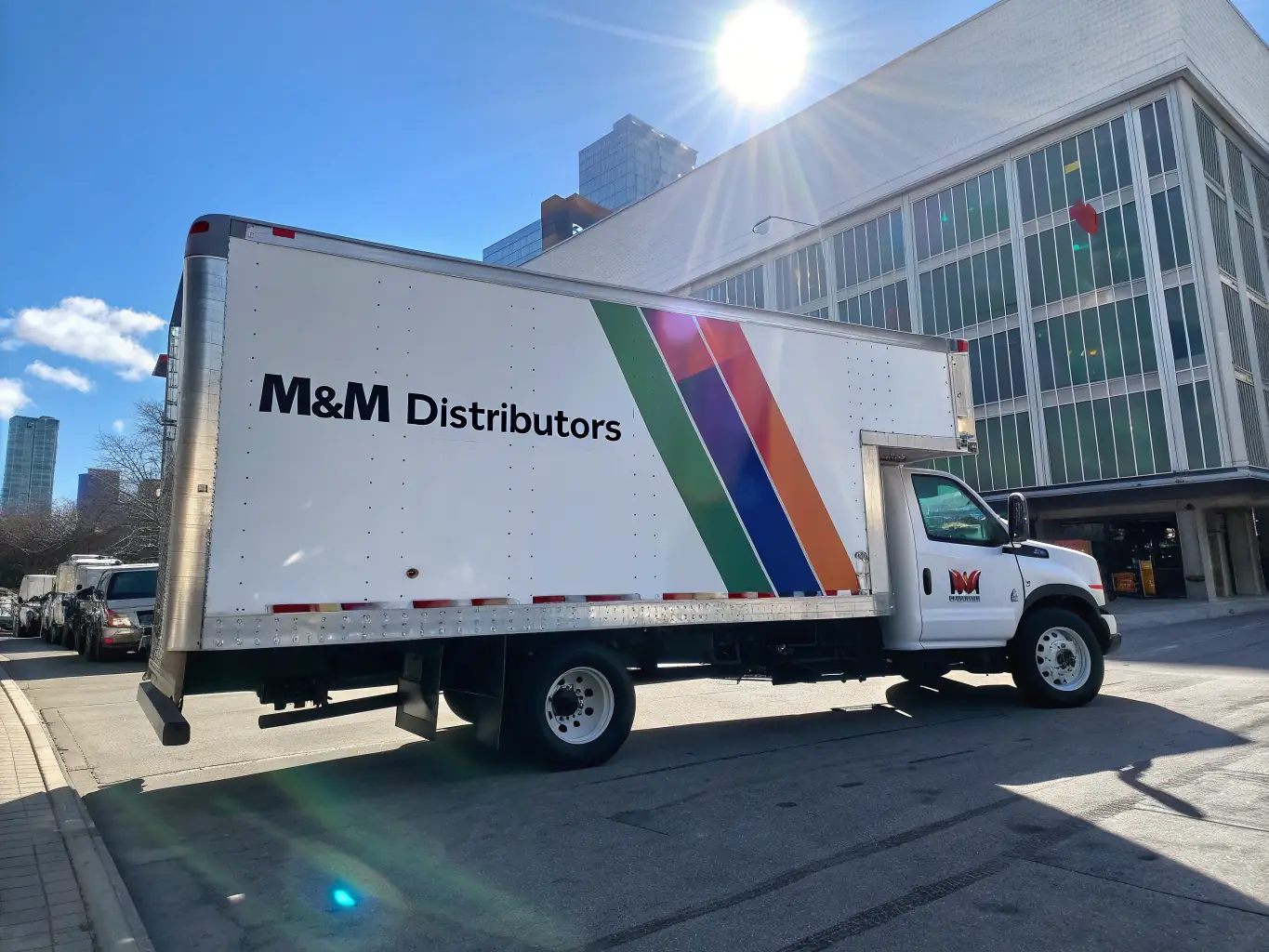 A dynamic shot of a delivery truck leaving a warehouse, symbolizing timely and reliable distribution services. The truck features the Ymsh logo and branding.
